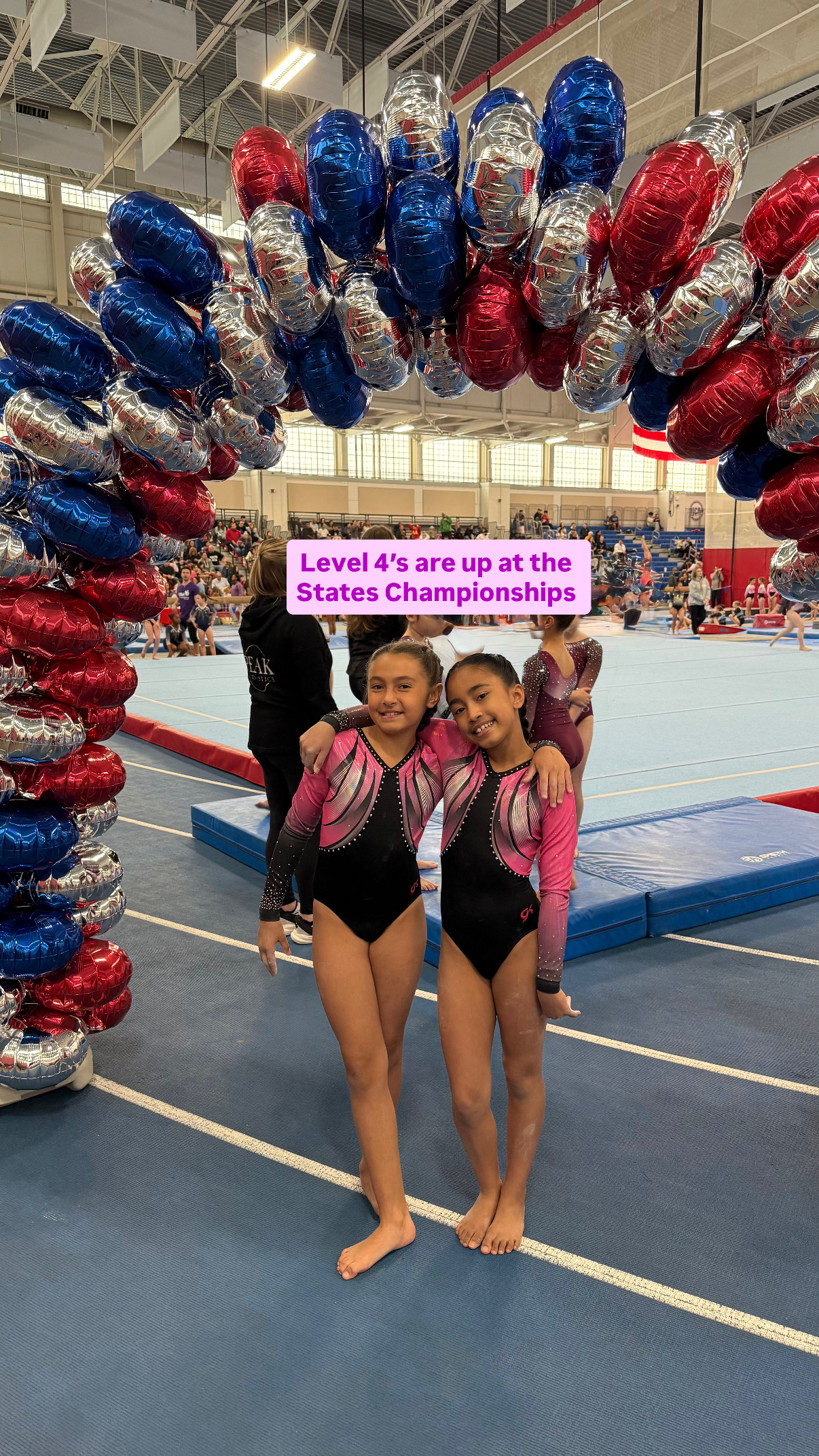 Team gymnasts posing in competition leotards at a meet