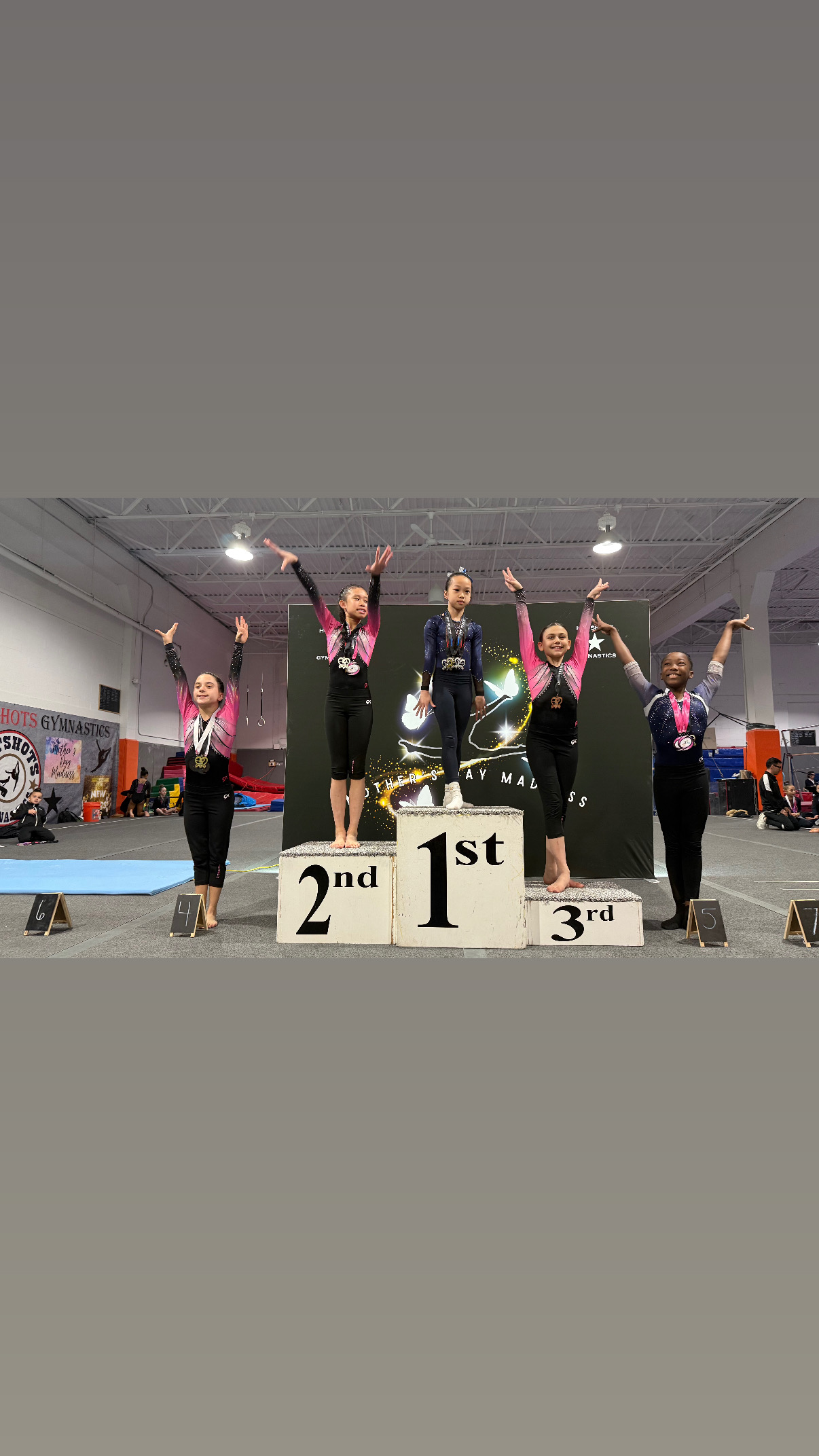 Gymnasts on competition podium celebrating first second and third place