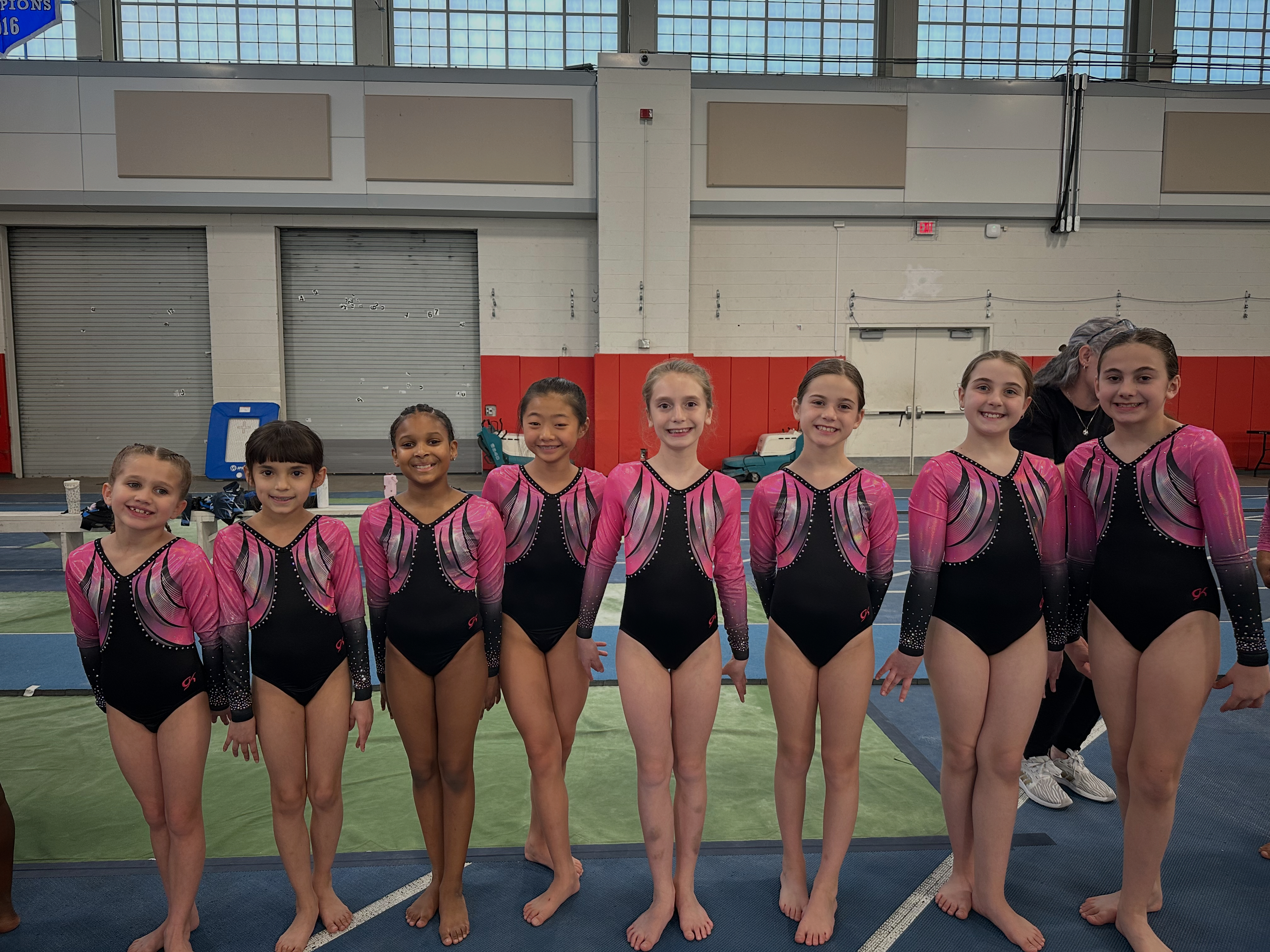 Small team group photo with medals at competition backdrop
