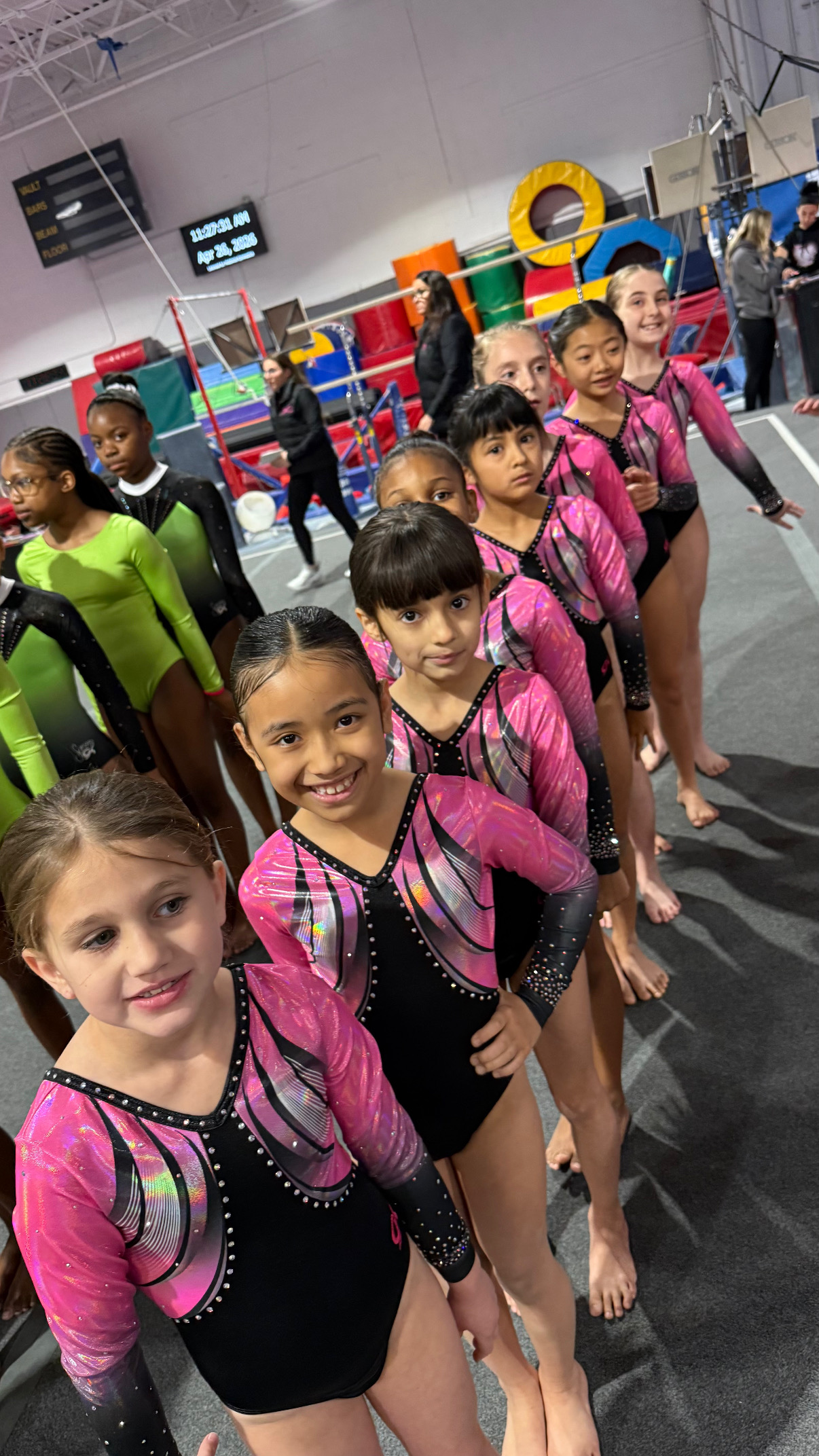 Team gymnasts lining up at competition floor