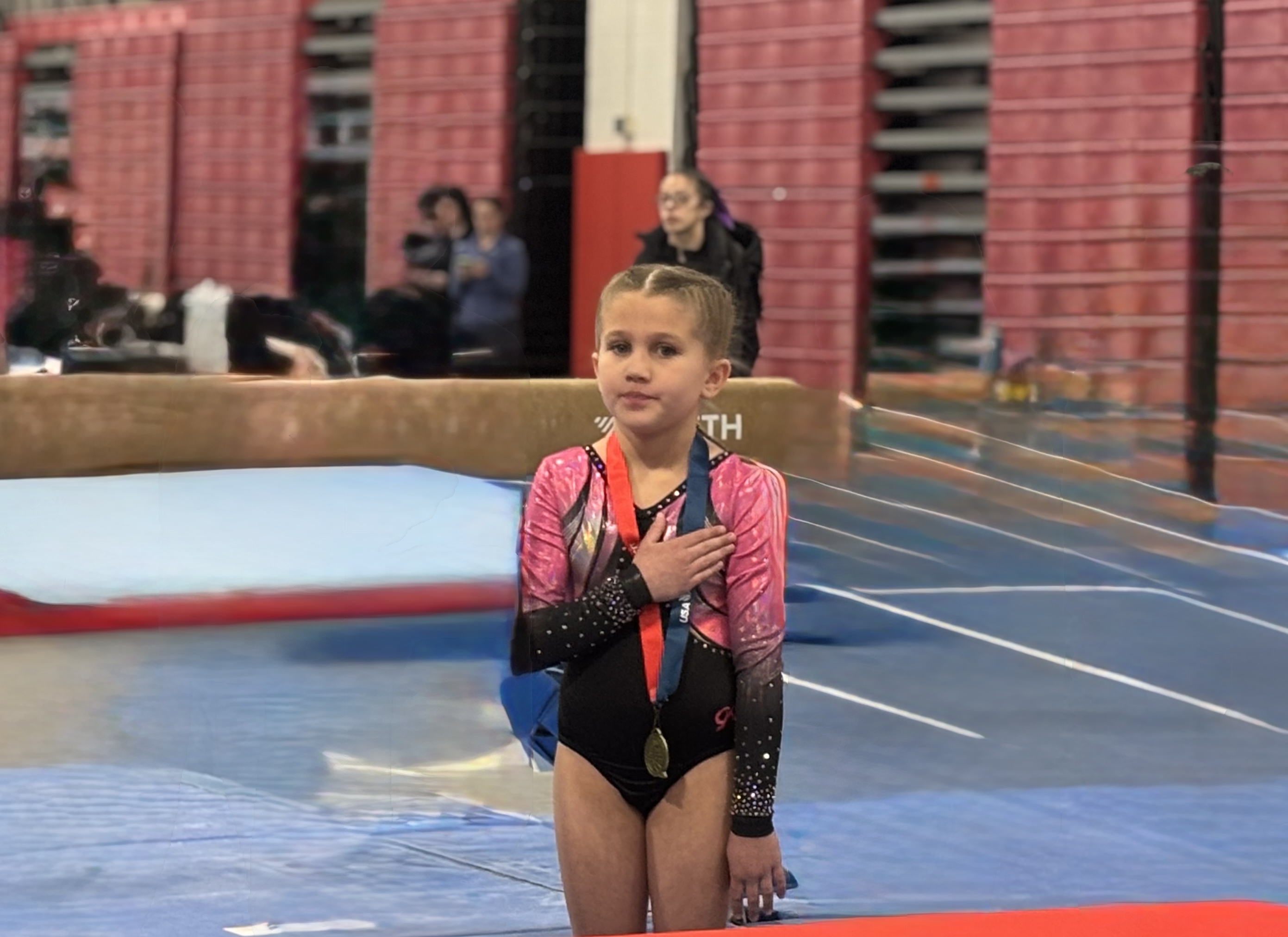 Gymnasts on awards stage with illuminated number stands