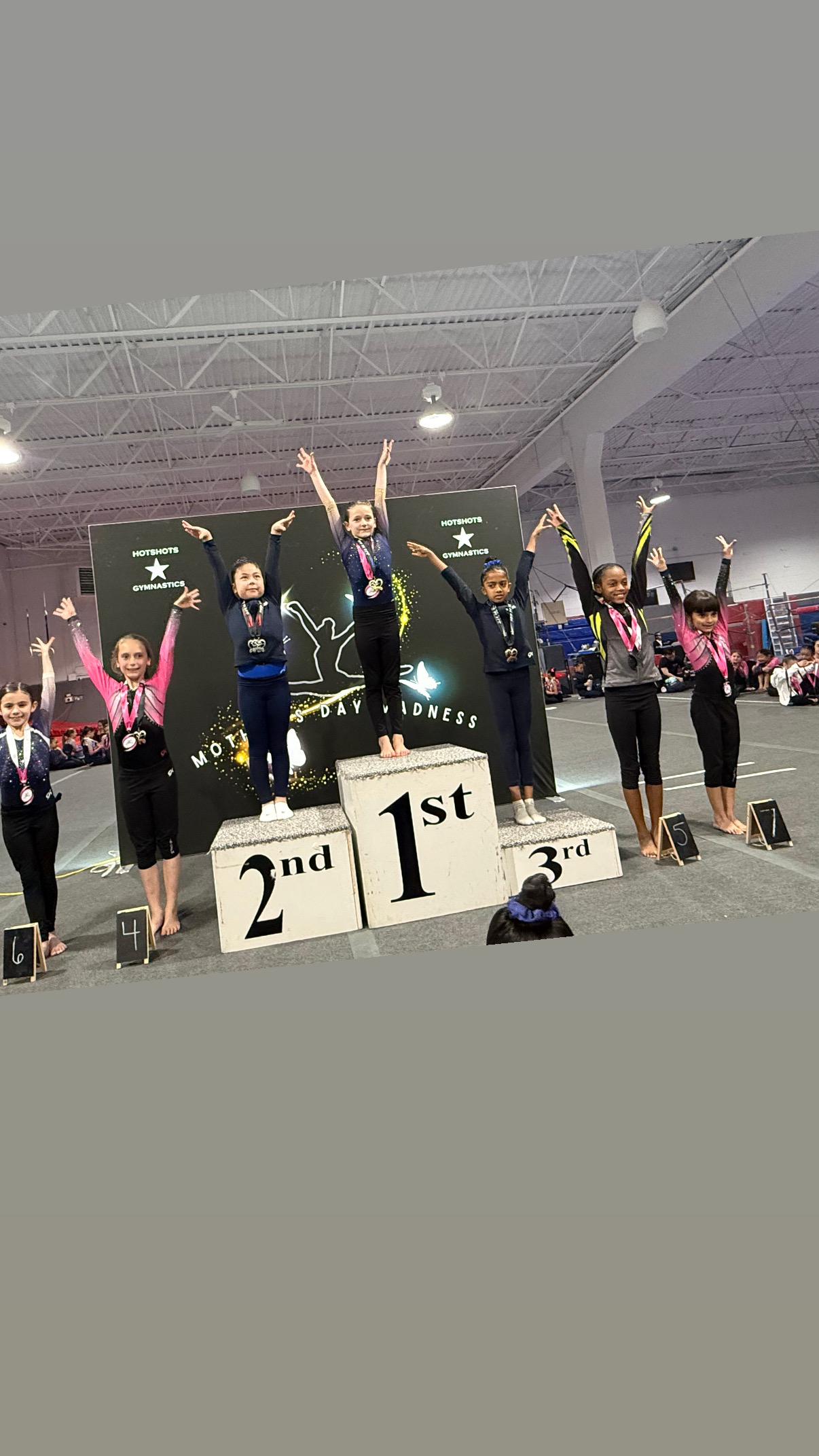Gymnasts celebrating with podium finishes at competition