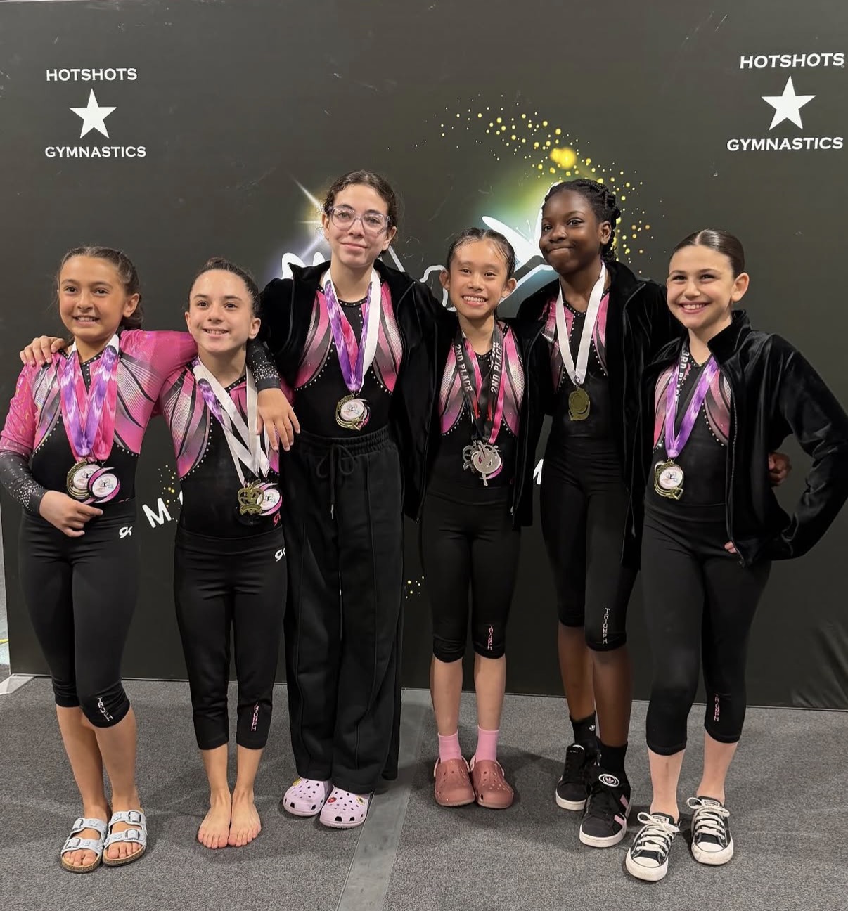 Gymnasts on awards stage with illuminated number plaques