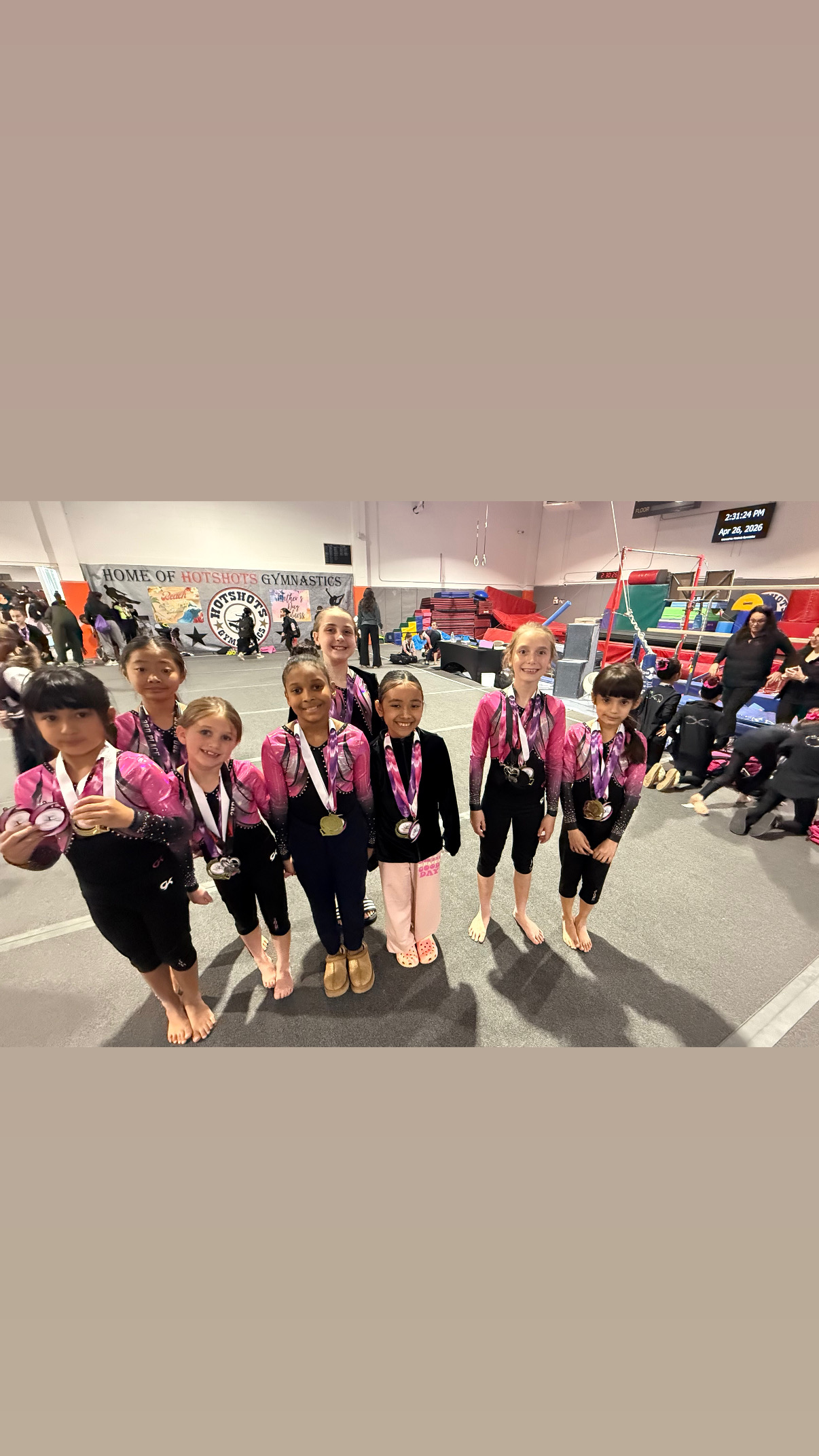 Team gymnasts lined up in gym wearing Triumph leotards