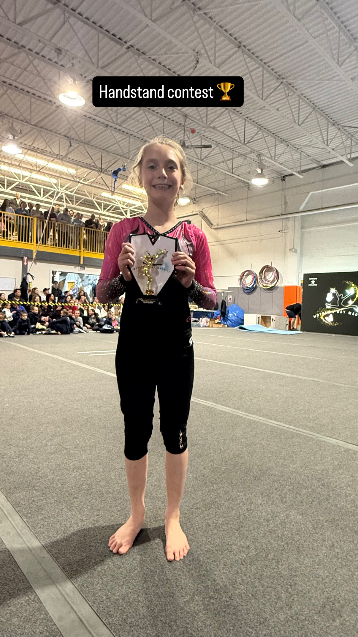 Gymnast holding trophy at gym competition