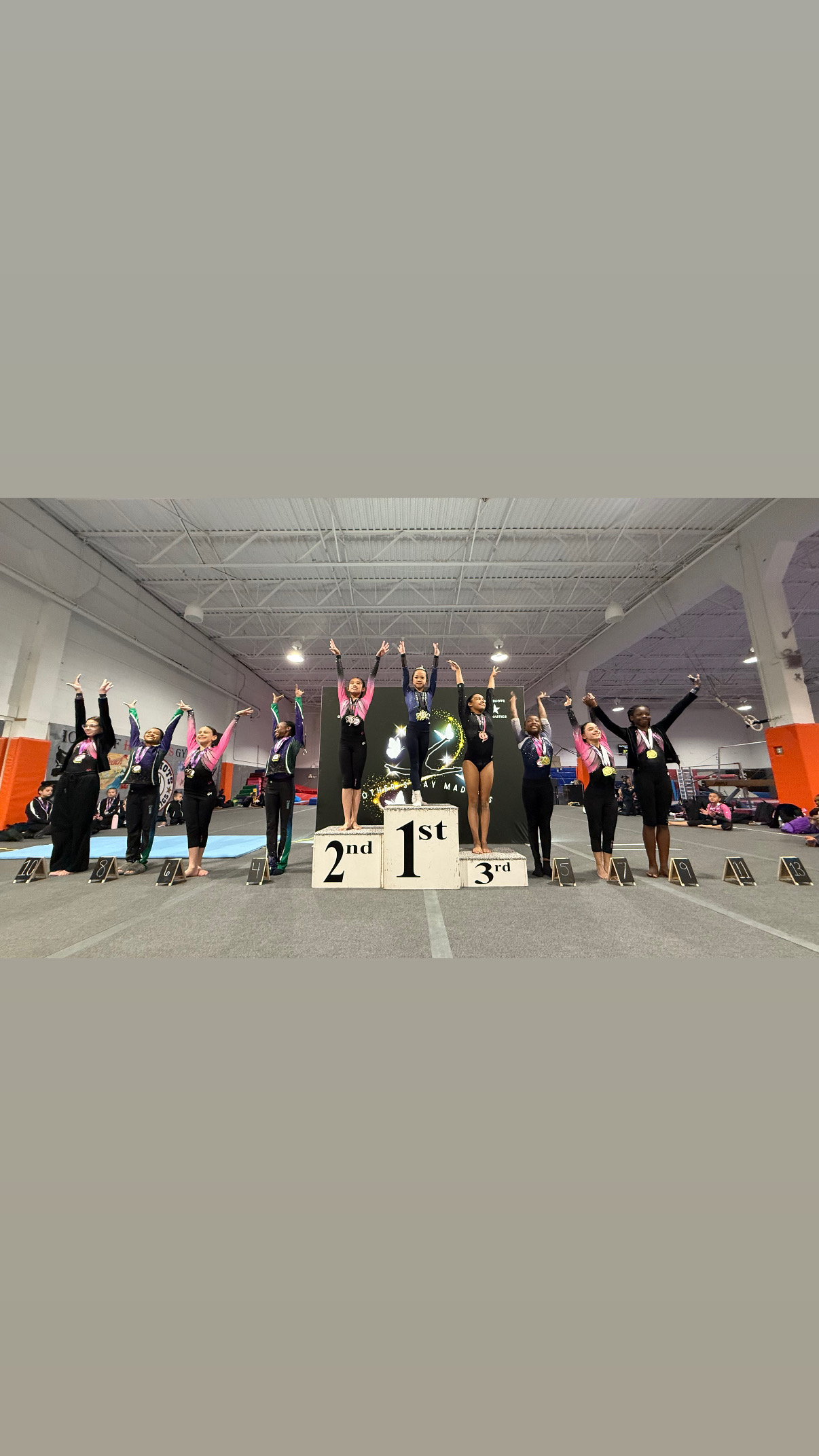 Competition podium with gymnasts celebrating placement