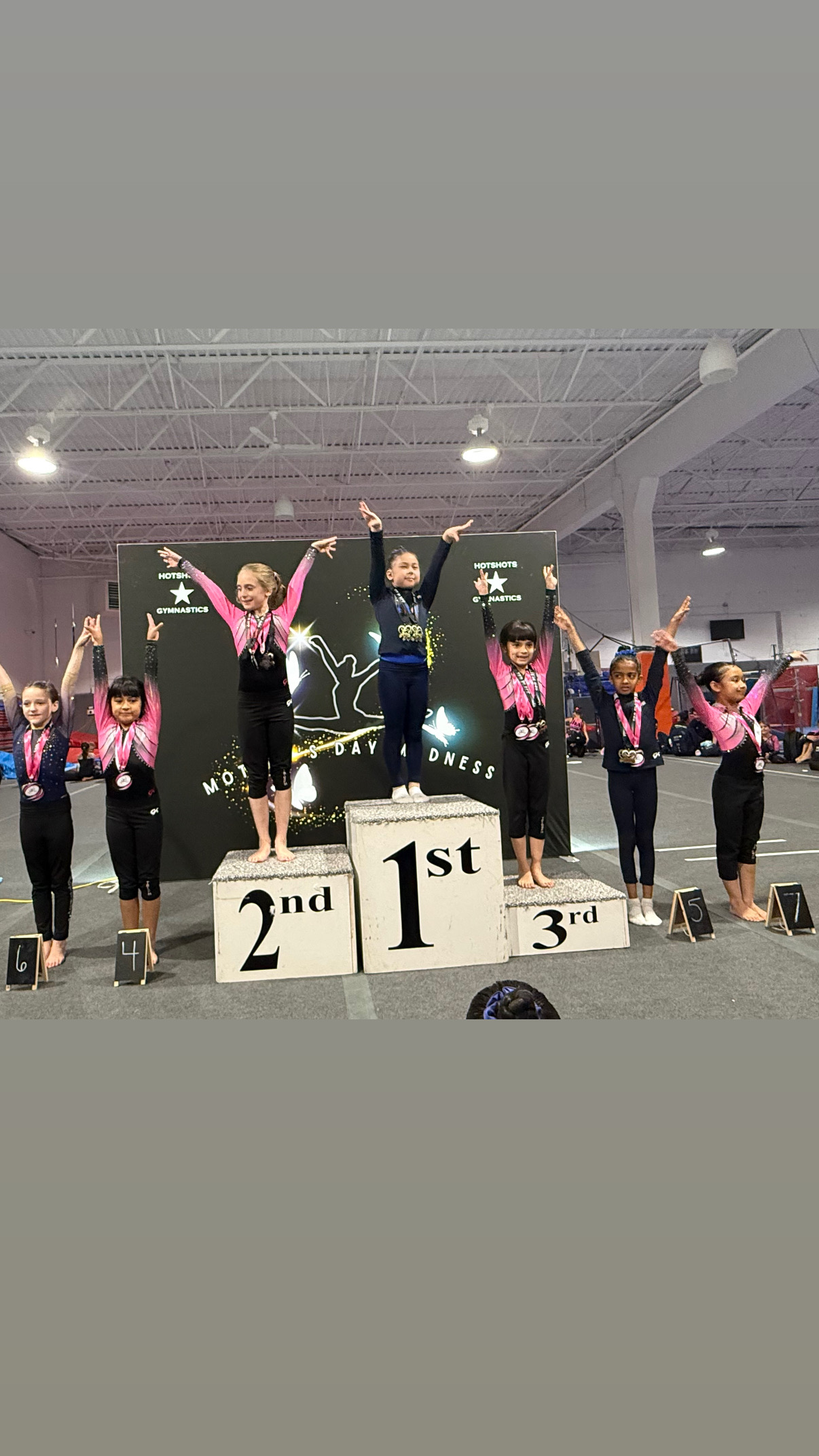 Small gymnast with gold medal and hand on chest