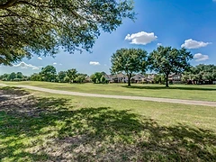 Backyard view with green lawn and trees near the houses
