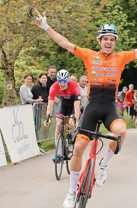 Cycliste franchissant la ligne d'arrivée bras levés — performance et podium