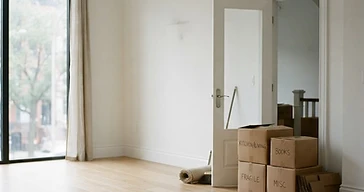 Sala de estar moderna e tranquila, vazia, com caixas de mudança junto à porta