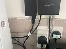 Mercusys network switch and power adapters neatly wall-mounted with PAT-tested sockets