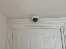 Hikvision dome camera mounted above an internal door frame