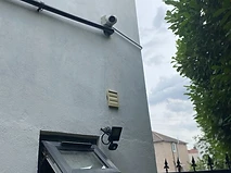 Perimeter dome camera and PIR floodlight on a rendered wall