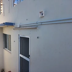 Neat parallel conduit cable management along rendered exterior wall