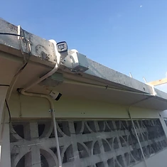 Two bullet cameras with tidy cabling under building overhang