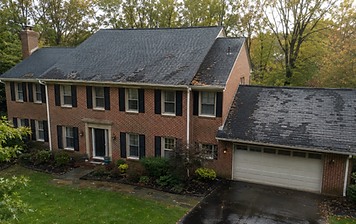 Two-story brick colonial home in Fairfax, Virginia with a dark architectural-shingle roof showing localized wear