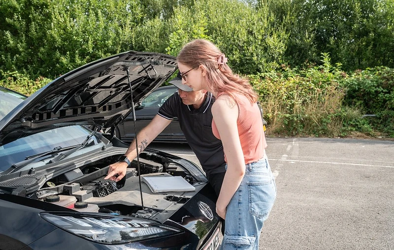 Instructor showing a learner under-bonnet vehicle safety checks