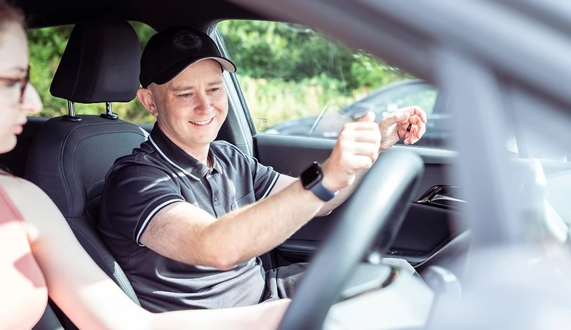 Driving instructor briefing a learner in a lesson car