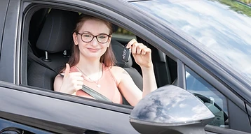 Learner holding car keys with a thumbs up after passing