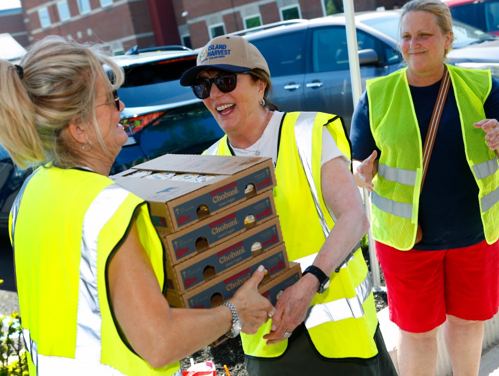 Island Harvest volunteers sharing a laugh at a food distribution