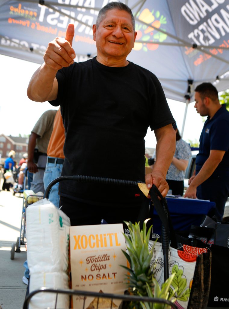 A neighbor gives a thumbs up at an Island Harvest distribution