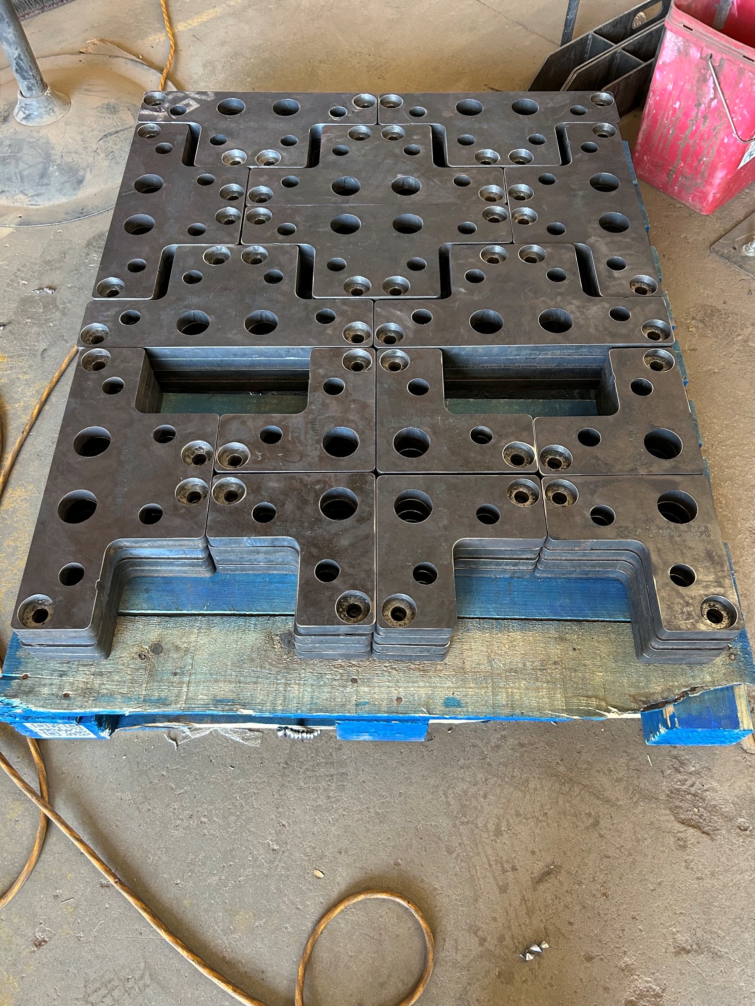 Stacked laser cut steel production components on a pallet at KorFab Phoenix facility