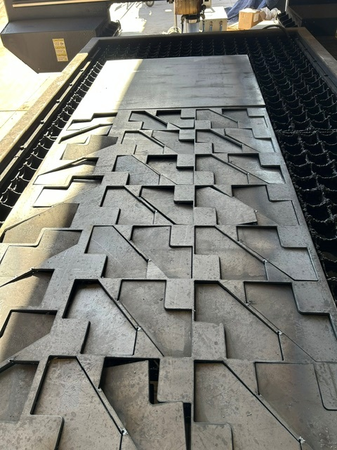 Precision laser-cut steel components on a KorFab cutting bed in Phoenix, Arizona