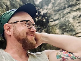 Kyle Piispanen in natural light against a rocky earthen wall