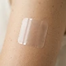 Macro close-up of a clear square PACHEEZ patch on skin