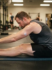 Adult man stretching on a gym mat in a quiet corner