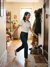 Adult woman walking briskly in natural morning window light in her apartment