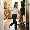 Adult woman walking briskly in natural morning window light in her apartment