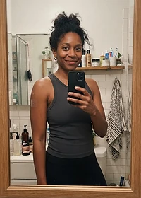 Adult woman in her 30s taking a casual bathroom mirror photo with a PACHEEZ patch on her arm