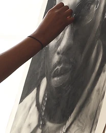 Artist working on large-scale charcoal portrait