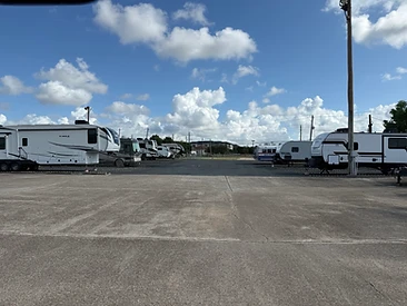RVs, fifth-wheels and travel trailers parked in the gated RV and boat parking lot at Challenger Storage