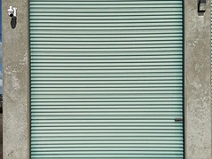 Security camera and exterior light mounted beside a drive-up storage unit at Challenger Storage