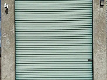 Security camera and exterior light mounted beside a drive-up storage unit at Challenger Storage