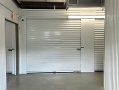 Inside the climate-controlled building at Challenger Storage, with security camera and unit doors