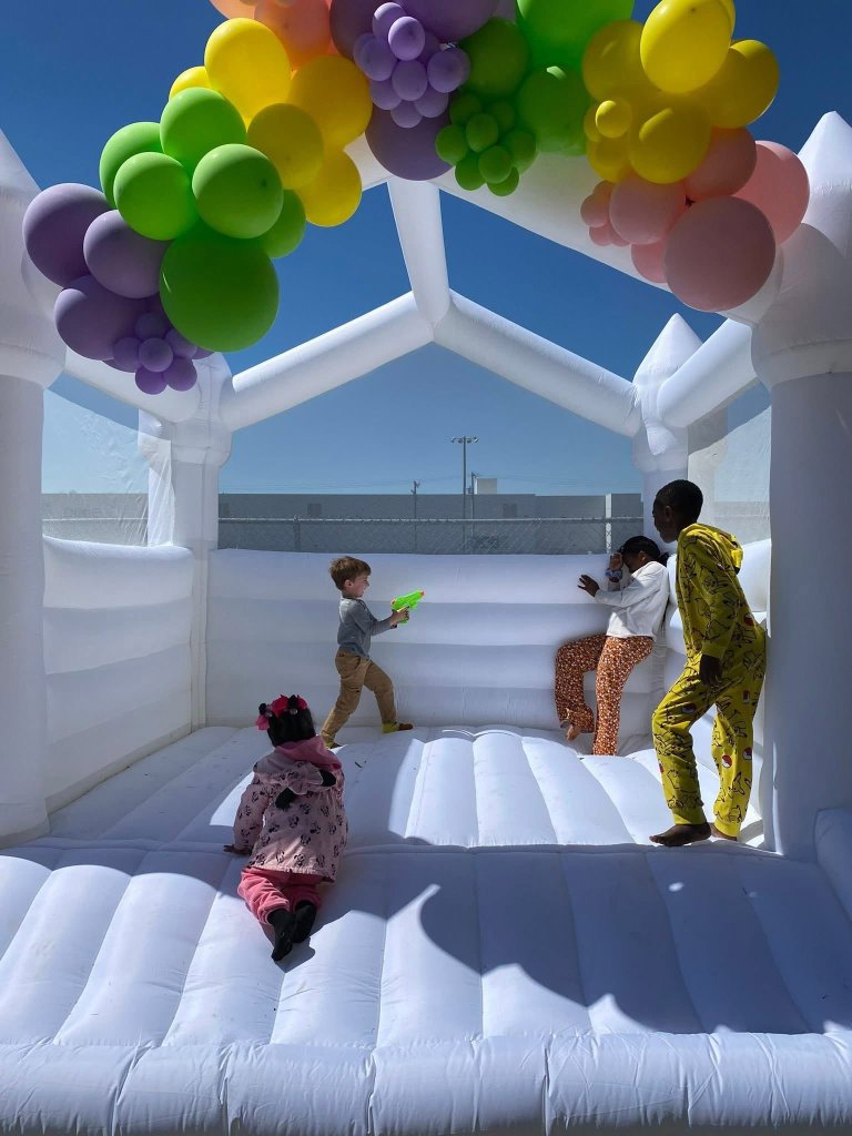 Kids playing inside white bounce house