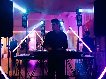 DJ con luci viola e rosa neon