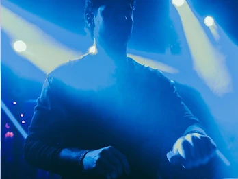 DJ con fasci di luce blu convergenti