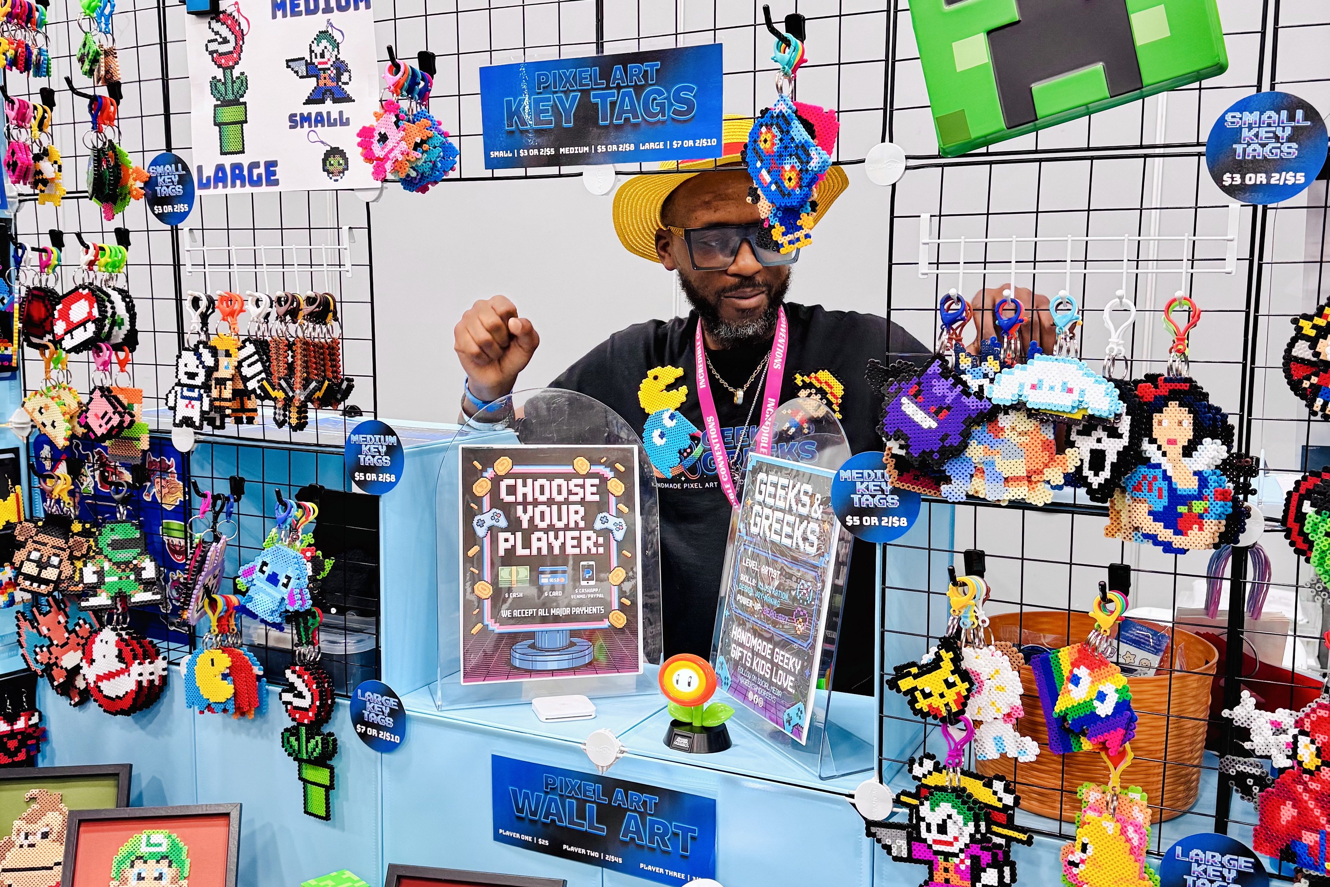 Hands placing perler beads on a pegboard