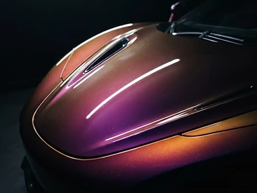 Purple-to-gold iridescent vinyl wrap on a luxury car hood