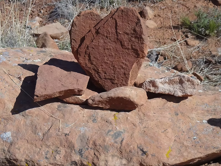 Naturally shaped heart stone resting among red rocks