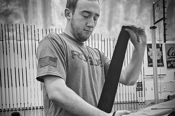 Dakota Brannan preparing for strength training by wrapping his wrists in a gym.
