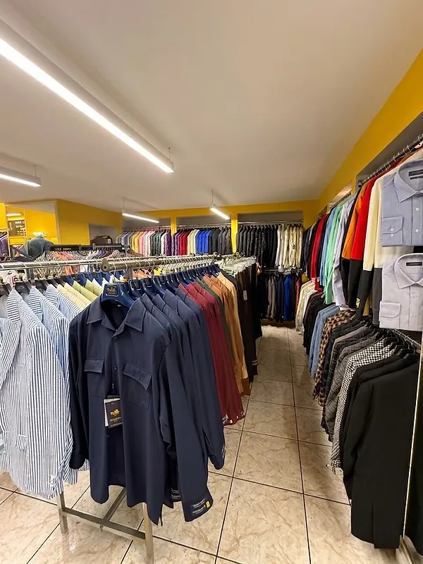 Aisle of dress shirts and sport coats organized by color in the Paolo Cellini showroom