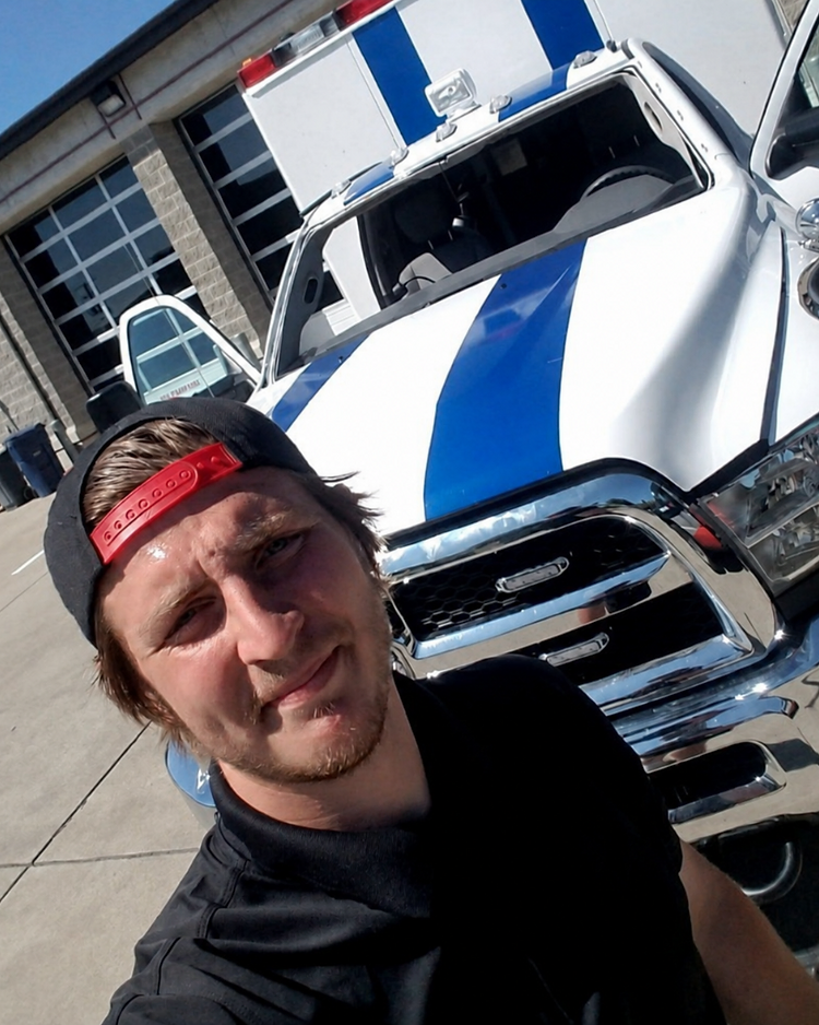 Trevor Pemberton, founder and owner of Auto Glass Guys, in front of a company work truck