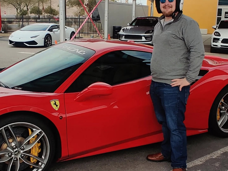 Christopher Thompson, co-founder and CMO of Auto Glass Guys, at a track day beside a red Ferrari