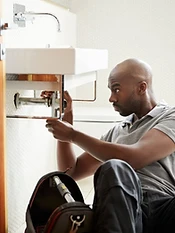 Plumber working under a sink