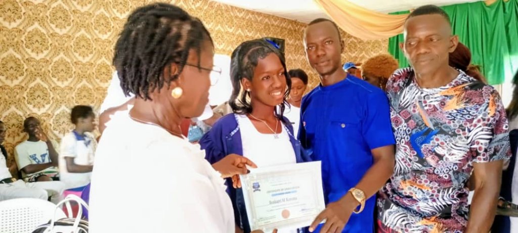 Victory Academy Pre/Primary School headmaster handing over a certificate to the best female student of the 2024-2025 academic year.